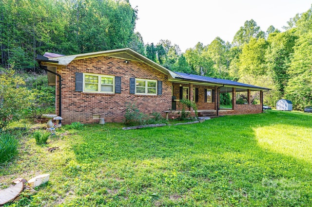 1300 Math Pl, Lenoir, NC 28645 - ranch-style house featuring a porch, a front yard, an outbuilding, brick siding, and a storage unit