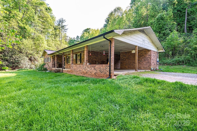 1300 Math Pl, Lenoir, NC 28645 - view of home's exterior with an attached carport, a yard, gravel driveway, and brick siding