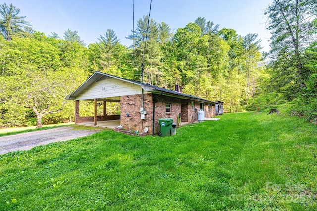 1300 Math Pl, Lenoir, NC 28645 - view of side of home with a lawn, brick siding, driveway, and a forest view