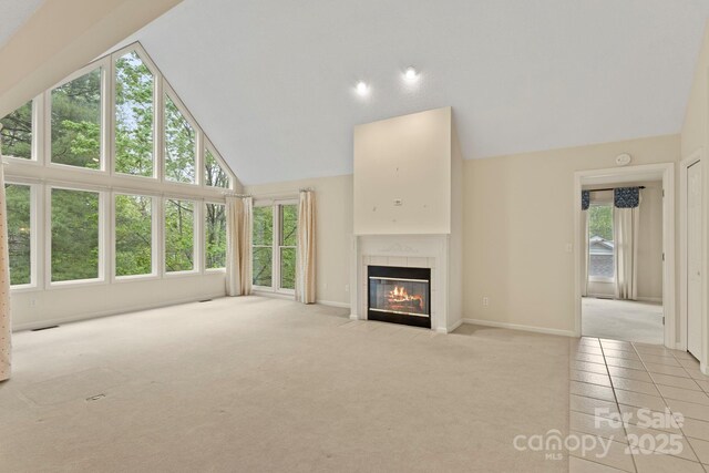 111 Broadmoor Dr, Flat Rock, NC 28731 - unfurnished living room featuring baseboards, high vaulted ceiling, a tile fireplace, and light colored carpet