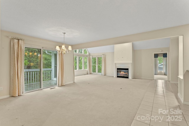 111 Broadmoor Dr, Flat Rock, NC 28731 - unfurnished living room featuring a notable chandelier, a glass covered fireplace, visible vents, baseboards, and light colored carpet
