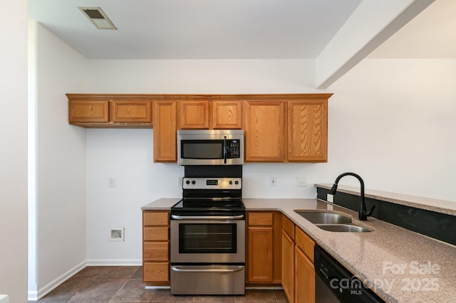 kitchen featuring light stone counters, a sink, brown cabinets, appliances with stainless steel finishes, and visible vents