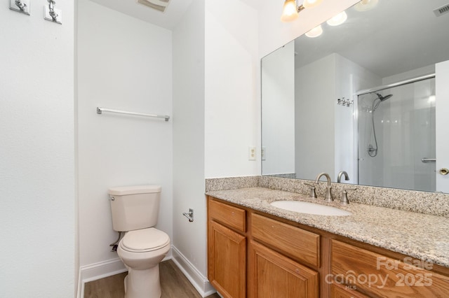 bathroom with a shower stall, wood finished floors, vanity, toilet, and visible vents