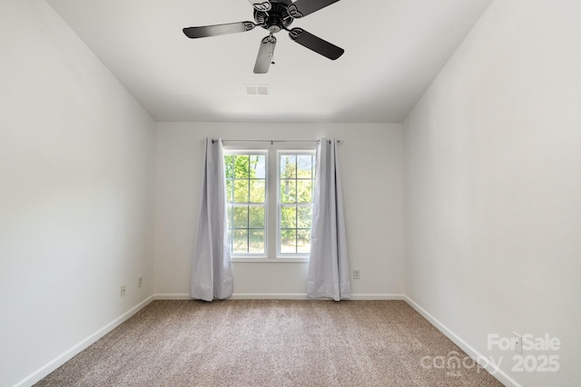 carpeted empty room with baseboards, visible vents, and ceiling fan