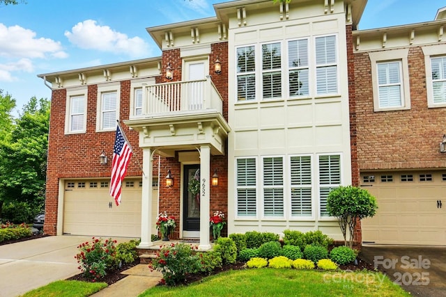 italianate home with brick siding, a garage, concrete driveway, and a balcony