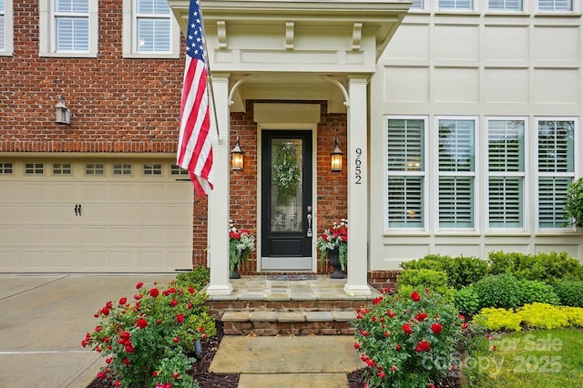 doorway to property featuring brick siding and concrete driveway