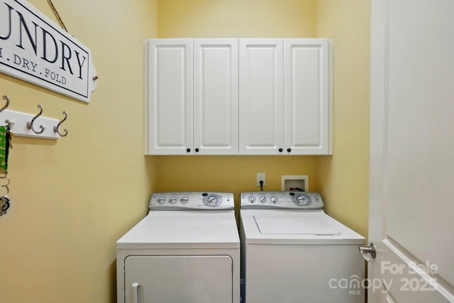 clothes washing area with cabinet space and washer and clothes dryer
