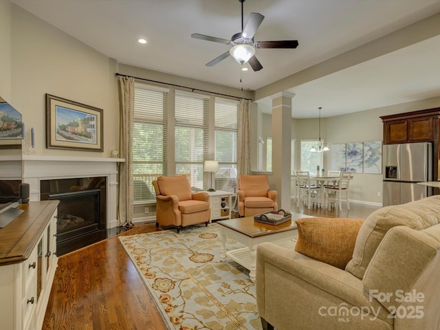 living area with ceiling fan, a high end fireplace, wood finished floors, baseboards, and recessed lighting