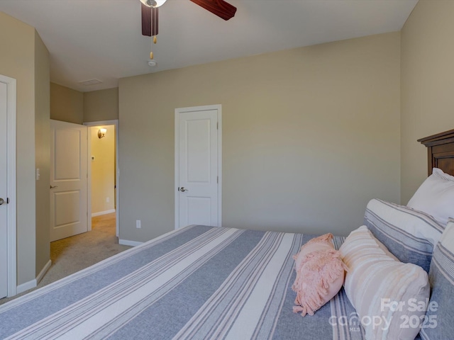 carpeted bedroom featuring baseboards and a ceiling fan