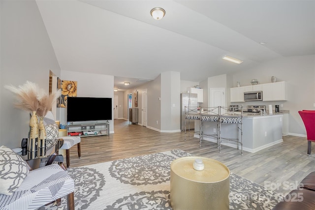1125 Silvertrace Dr, Salisbury, NC 28144 - living area with baseboards, vaulted ceiling, and light wood-style floors