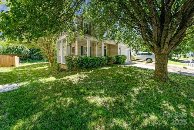 exterior space with concrete driveway, a front lawn, covered porch, and a garage