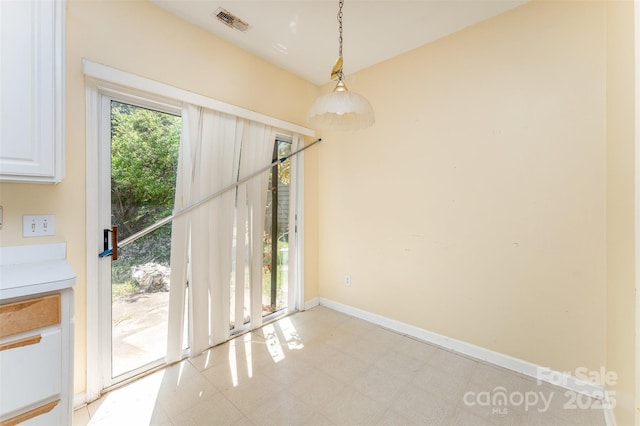 unfurnished dining area featuring light floors, baseboards, and visible vents