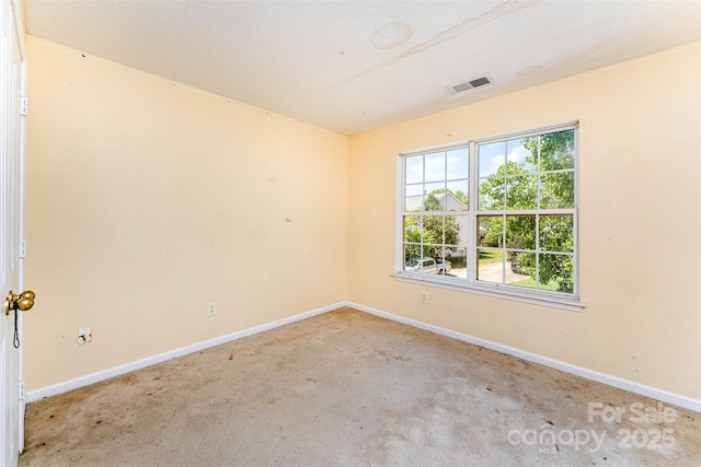 empty room featuring baseboards, visible vents, and carpet flooring