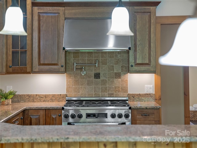 14 Sweet Gum Hl, Fletcher, NC 28732 - kitchen with high end range, wall chimney range hood, backsplash, light stone counters, and glass insert cabinets