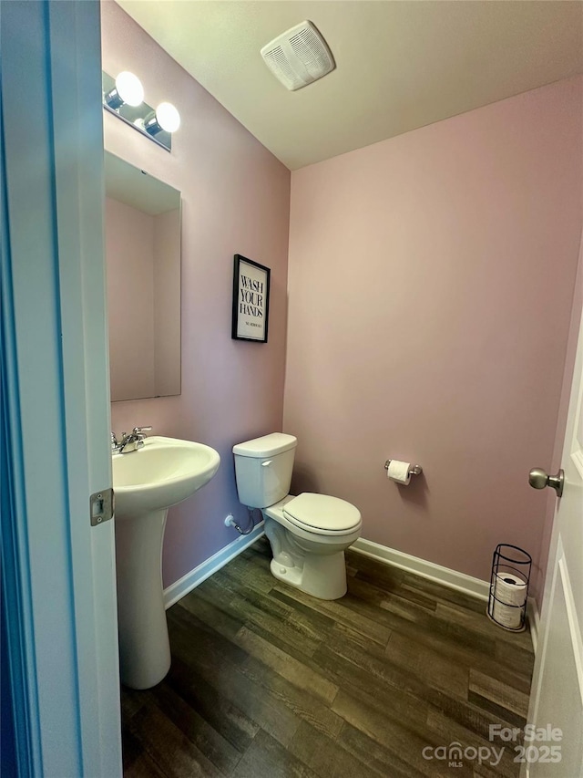 1070 Glenbriar Ct, Woodleaf, NC 27054 - bathroom with wood finished floors, toilet, a sink, baseboards, and visible vents