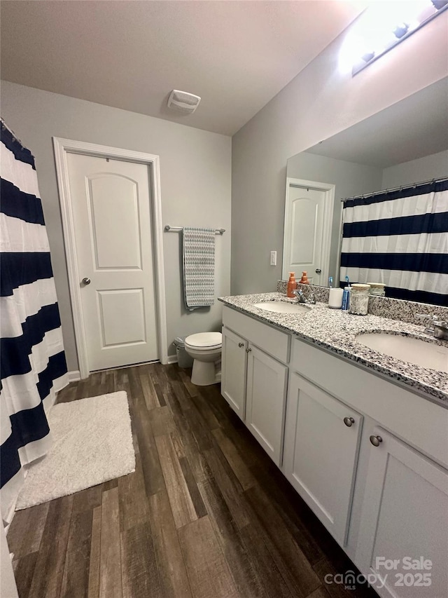 1070 Glenbriar Ct, Woodleaf, NC 27054 - full bath with wood finished floors, toilet, double vanity, and a sink