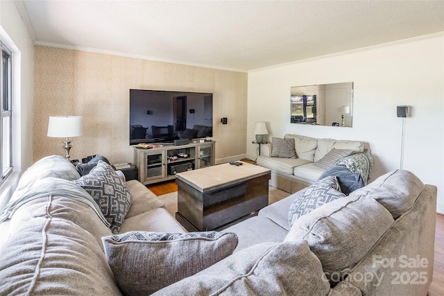 living room featuring wallpapered walls, wood finished floors, ornamental molding, and plenty of natural light