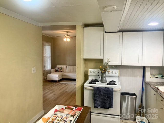 439 17th St, Cramerton, NC 28032 - kitchen with electric stove, white cabinets, a ceiling fan, wood finished floors, and crown molding