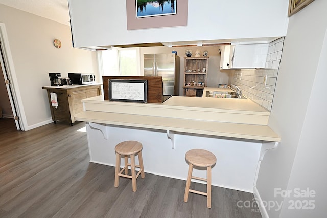 2263 Starbrooke Dr, Newton, NC 28658 - kitchen featuring appliances with stainless steel finishes, a sink, dark wood finished floors, white cabinetry, and tasteful backsplash