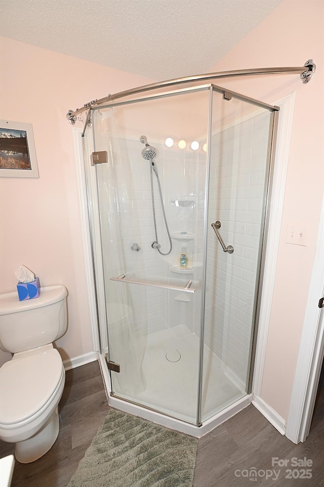 2263 Starbrooke Dr, Newton, NC 28658 - full bathroom featuring baseboards, a stall shower, wood finished floors, and toilet