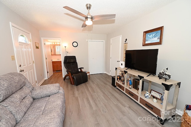 2263 Starbrooke Dr, Newton, NC 28658 - living room featuring light wood-type flooring, a ceiling fan, a textured ceiling, and baseboards