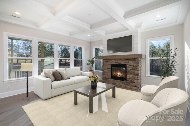 living area with coffered ceiling, beam ceiling, a wealth of natural light, and a fireplace