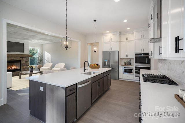 kitchen with a sink, appliances with stainless steel finishes, white cabinets, dark wood-style flooring, and recessed lighting