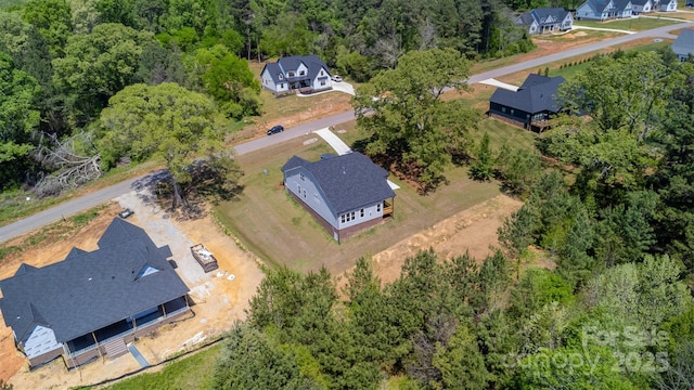 drone / aerial view with a forest view and a residential view