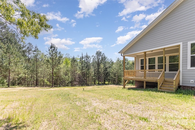 view of yard with a wooden deck and a wooded view