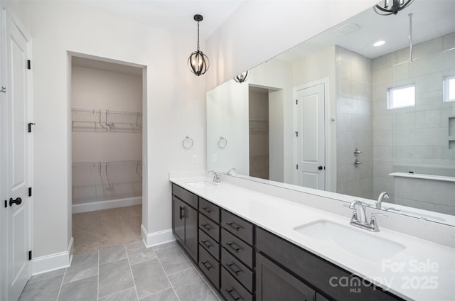 full bathroom featuring baseboards, a sink, a walk in shower, and double vanity