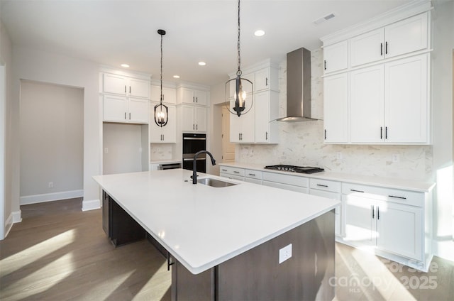 kitchen with a sink, wall chimney exhaust hood, light wood-style flooring, gas stovetop, and white cabinetry
