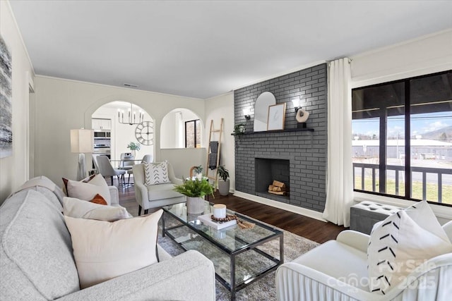 2609 Lowell Rd, Gastonia, NC 28054 - living area featuring an inviting chandelier, a fireplace, wood finished floors, and a wealth of natural light
