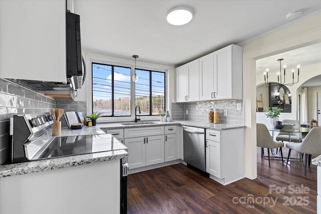 2609 Lowell Rd, Gastonia, NC 28054 - kitchen featuring dark wood finished floors, stainless steel appliances, a sink, arched walkways, and light stone countertops