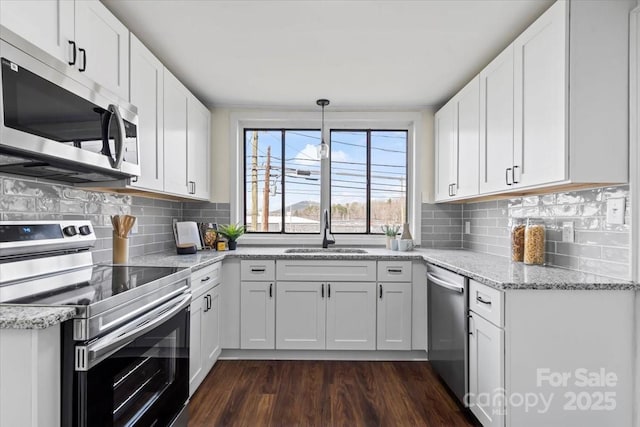 2609 Lowell Rd, Gastonia, NC 28054 - kitchen featuring light stone counters, a sink, appliances with stainless steel finishes, white cabinetry, and dark wood-style flooring