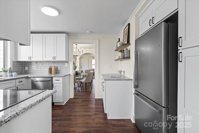 2609 Lowell Rd, Gastonia, NC 28054 - kitchen featuring white cabinets, dark wood finished floors, light stone countertops, decorative backsplash, and appliances with stainless steel finishes