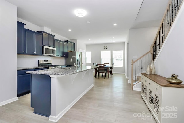 147 Morning Gap Pkwy, Fort Mill, SC 29715 - kitchen featuring a kitchen breakfast bar, a sink, an island with sink, stainless steel appliances, and light stone countertops