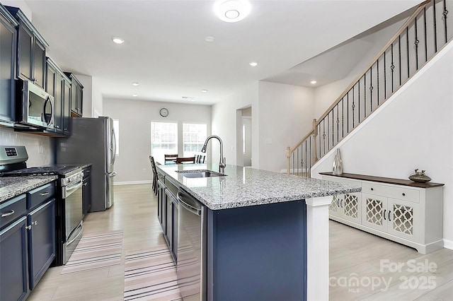147 Morning Gap Pkwy, Fort Mill, SC 29715 - kitchen featuring light stone counters, light wood-style flooring, stainless steel appliances, and a sink