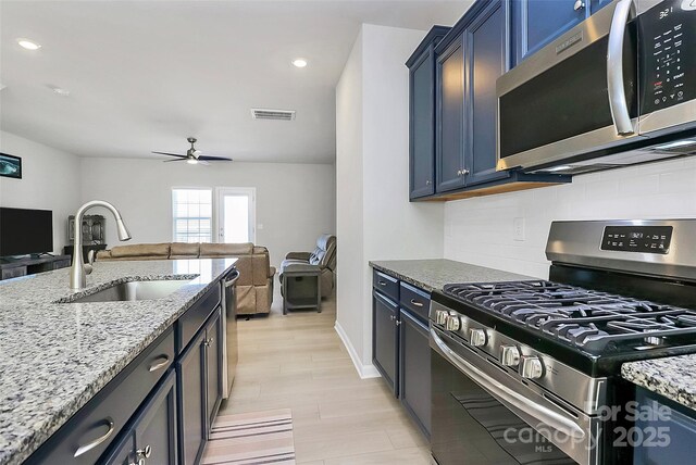 147 Morning Gap Pkwy, Fort Mill, SC 29715 - kitchen featuring light stone counters, stainless steel appliances, visible vents, a sink, and open floor plan