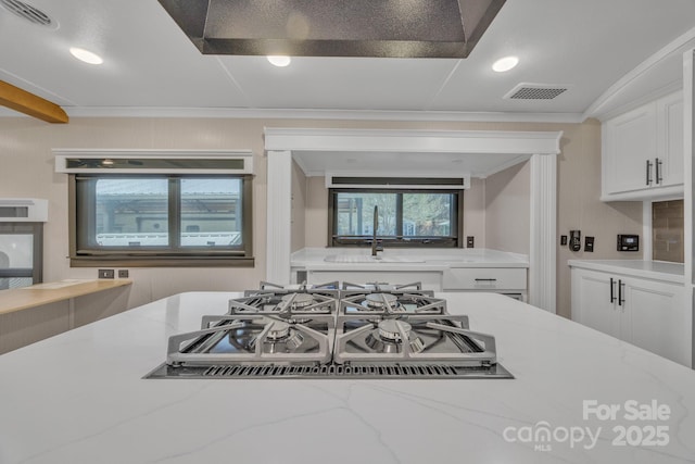 kitchen featuring gas cooktop, ornamental molding, white cabinets, light stone counters, and recessed lighting