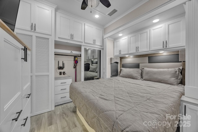bedroom featuring crown molding, light wood finished floors, and recessed lighting