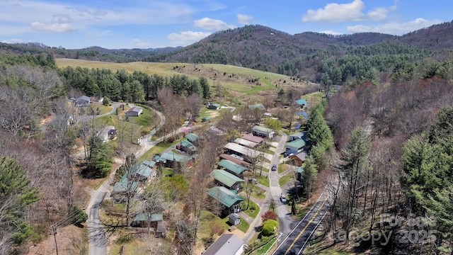 aerial view of property's location featuring mountains and a heavily wooded area