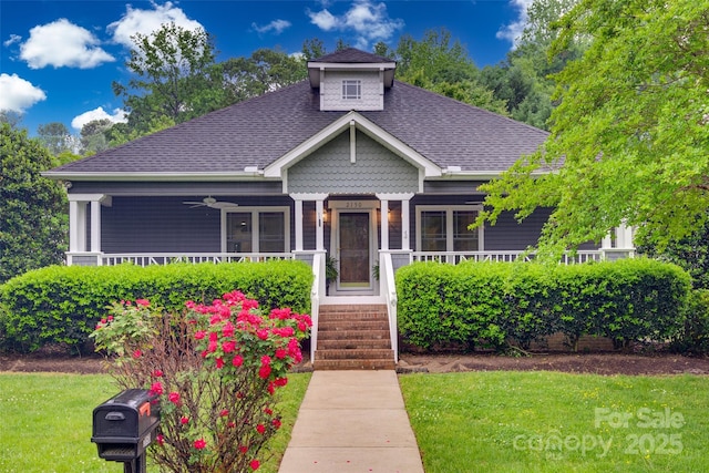 bungalow featuring a front lawn, a porch, a ceiling fan, and a shingled roof