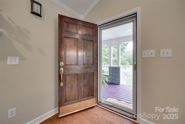 entryway with baseboards, ornamental molding, and wood finished floors