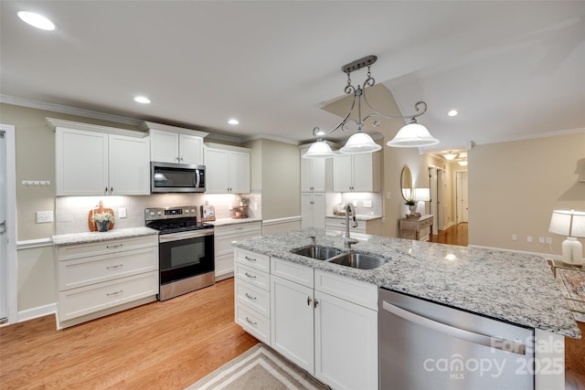 kitchen featuring ornamental molding, a sink, white cabinetry, and appliances with stainless steel finishes
