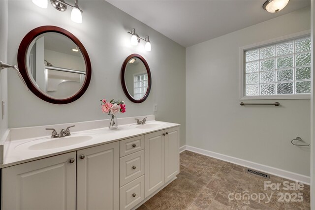 full bathroom with a wealth of natural light, visible vents, and a sink