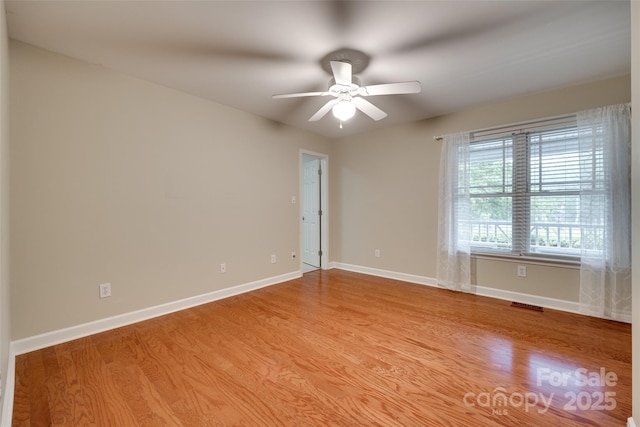 unfurnished room featuring ceiling fan, baseboards, visible vents, and light wood-style flooring
