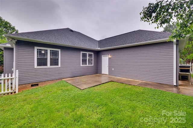 rear view of property featuring fence, a lawn, roof with shingles, and a patio