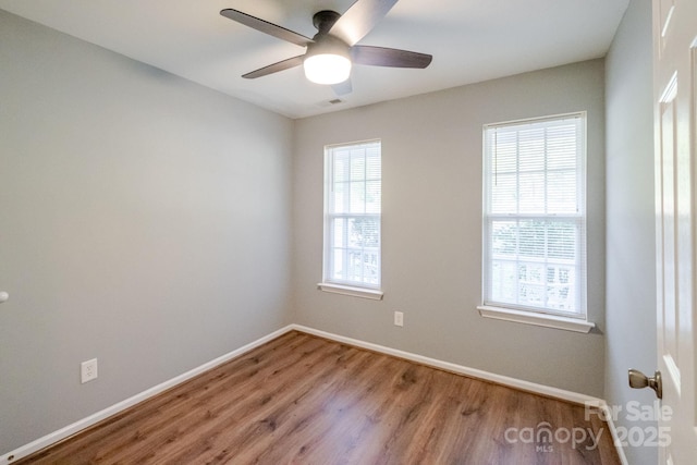 spare room featuring baseboards, a ceiling fan, and wood finished floors