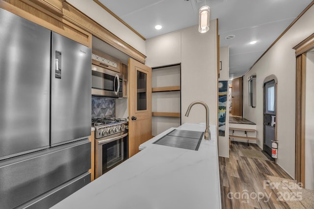 kitchen with stainless steel appliances, a sink, dark wood-style flooring, backsplash, and recessed lighting