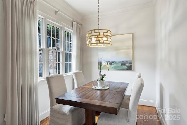 dining space with wood finished floors, baseboards, and an inviting chandelier